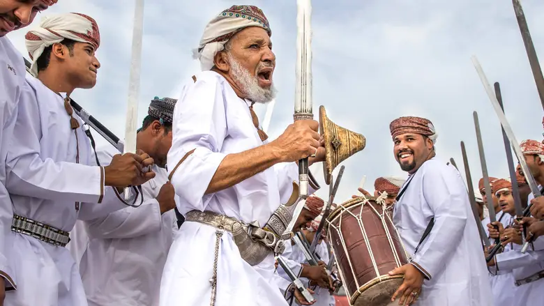 موسیقی سنتی عمان: آواهایی از دل تاریخ (معرفی انواع موسیقی سنتی و سازهای مورد استفاده) موسیقی سنتی عمان، گنجینهای ارزشمند از آواها و نواهایی است که ریشه در تاریخ و فرهنگ این سرزمین دارد. این موسیقی، بازتابی از زندگی، باورها، آداب و رسوم و احساسات مردم عمان است و در طول قرنها، سینهبهسینه به نسلهای بعدی منتقل شده است. در این مقاله، به معرفی انواع موسیقی سنتی عمان و سازهای مورد استفاده در این موسیقی میپردازیم: 1. انواع موسیقی سنتی عمان: موسیقی دریایی (Sea Music): این نوع موسیقی، مرتبط با زندگی دریایی و ماهیگیری است و معمولاً در مراسمها و جشنهای مربوط به دریا اجرا میشود. لیوا (Liwa): نوعی موسیقی و رقص است که توسط جوامع آفریقاییتبار در عمان اجرا میشود و ریتمهای تند و پرانرژی دارد. فنون البحار (Funun Al-Bihar): شامل انواع مختلفی از آوازها و رقصها است که توسط دریانوردان و ماهیگیران اجرا میشود. موسیقی بدوی (Bedouin Music): این نوع موسیقی، مرتبط با زندگی بیابانی و عشایری است و معمولاً در مراسمها و جشنهای قبیلهای اجرا میشود. الرزحه (Al-Razha): نوعی موسیقی و رقص است که توسط مردان قبایل اجرا میشود و شامل شعرخوانی، شمشیربازی و حرکات موزون است. العازی (Al-Aazi): نوعی موسیقی و شعرخوانی است که توسط زنان قبایل اجرا میشود و معمولاً در مراسمهای عروسی و جشنهای خانوادگی اجرا میشود. موسیقی مذهبی (Religious Music): این نوع موسیقی، مرتبط با مراسمها و مناسبتهای مذهبی است و معمولاً در مساجد و اماکن مذهبی اجرا میشود. المدیح (Al-Madih): نوعی موسیقی و شعرخوانی است که در مدح پیامبر اسلام (ص) و ائمه اطهار (ع) اجرا میشود. الزیاره (Al-Ziyara): نوعی موسیقی و شعرخوانی است که در زیارتگاهها و اماکن متبرکه اجرا میشود. موسیقی درباری (Court Music): این نوع موسیقی، مرتبط با دربار و خاندان سلطنتی است و معمولاً در مراسمها و جشنهای رسمی اجرا میشود. النازک (Al-Nazak): نوعی موسیقی و رقص است که توسط زنان دربار اجرا میشود و شامل حرکات ظریف و موزون است. البرعه (Al-Bar’ah): نوعی موسیقی و رقص است که توسط مردان دربار اجرا میشود و شامل شمشیربازی و حرکات نمایشی است. موسیقی محلی (Local Music): این نوع موسیقی، مرتبط با مناطق مختلف عمان است و هر منطقه دارای سبک و ویژگیهای خاص خود است. الدان الدانه (Dan Al-Dana): نوعی موسیقی و رقص است که در منطقه ظفار اجرا میشود و شامل ریتمهای شاد و پرانرژی است. الشوبانی (Shubani): نوعی موسیقی و رقص است که در منطقه مسندم اجرا میشود و شامل حرکات سریع و پیچیده است. 2. سازهای مورد استفاده در موسیقی سنتی عمان: عود (Oud): عود یک ساز زهی است که به عنوان یکی از مهمترین سازهای موسیقی عربی شناخته میشود و در موسیقی سنتی عمان نیز کاربرد فراوانی دارد. قانون (Qanun): قانون یک ساز زهی است که دارای صدایی دلنشین و لطیف است و در موسیقی سنتی عمان به عنوان یک ساز ملودیک مورد استفاده قرار میگیرد. نای (Nay): نای یک ساز بادی است که دارای صدایی غمانگیز و عرفانی است و در موسیقی سنتی عمان به عنوان یک ساز همراهیکننده مورد استفاده قرار میگیرد. طبله (Tabla): طبله یک ساز کوبهای است که دارای صدایی ریتمیک و پرانرژی است و در موسیقی سنتی عمان به عنوان یک ساز ریتمیک مورد استفاده قرار میگیرد. دف (Daf): دف یک ساز کوبهای است که دارای صدایی شاد و پرشور است و در موسیقی سنتی عمان به عنوان یک ساز ریتمیک مورد استفاده قرار میگیرد. ربابه (Rebab): ربابه یک ساز زهی است که دارای صدایی غمانگیز و دلنشین است و در موسیقی بدوی عمان به عنوان یک ساز همراهیکننده مورد استفاده قرار میگیرد. مزمار (Mizmar): مزمار یک ساز بادی است که دارای صدایی بلند و رسا است و در موسیقی دریایی عمان به عنوان یک ساز همراهیکننده مورد استفاده قرار میگیرد. 3. نقش موسیقی سنتی در فرهنگ عمان: حفظ هویت: موسیقی سنتی نمادی از هویت و فرهنگ عمانی است. انتقال سنتها: موسیقی سنتی به انتقال سنتها و آداب و رسوم به نسلهای بعدی کمک میکند. تعبیر احساسات: موسیقی سنتی به مردم عمان امکان میدهد تا احساسات خود را بیان کنند. جشن و سرور: موسیقی سنتی در مراسمها و جشنها برای ایجاد شادی و سرور مورد استفاده قرار میگیرد. گردشگری: موسیقی سنتی جاذبهای برای گردشگران است و به معرفی فرهنگ عمان کمک میکند. 4. چالشها و راهکارها: تغییر سبک زندگی: با ورود مدرنیته و تغییر سبک زندگی، ممکن است علاقه به موسیقی سنتی کاهش یابد. حفظ سنتها: آموزش به نسلهای جوان در مورد اهمیت و ارزش موسیقی سنتی، ضروری است. حمایت: دولت و سازمانهای غیردولتی باید از هنرمندان و نوازندگانی که در زمینه موسیقی سنتی فعالیت میکنند، حمایت کنند. ترویج: برگزاری کنسرتها و جشنوارههای موسیقی سنتی، به ترویج این هنر کمک میکند. موسیقی سنتی عمان، میراثی ارزشمند است که باید حفظ و به نسلهای آینده منتقل شود. این موسیقی نه تنها نمادی از هویت و فرهنگ عمانی است، بلکه زبانی جهانی است که میتواند با قلبها و روحهای مردم در سراسر جهان ارتباط برقرار کند.